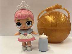 A toy doll next to a plastic bottle
Description automatically generated